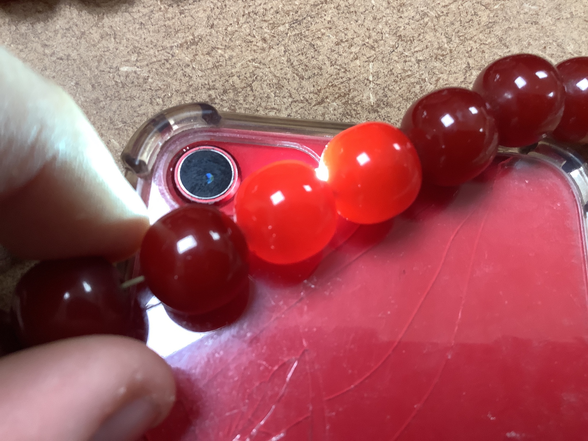 A group of loose simulated cherry amber beads and one other similar necklace, gross weight 254 grams.